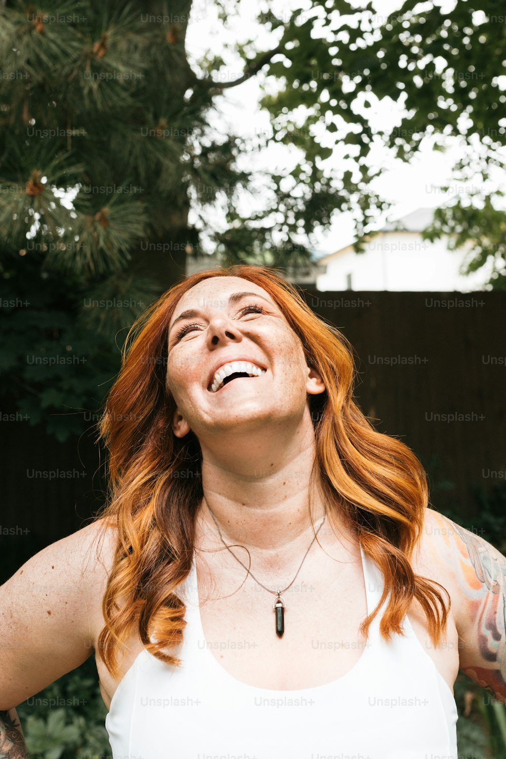a woman with red hair is smiling and looking up