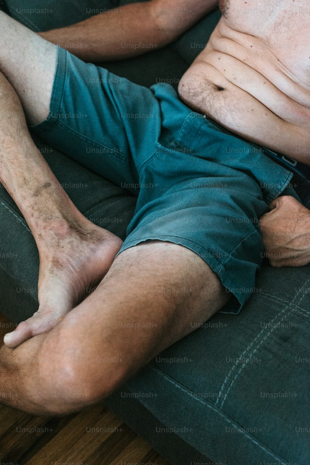 um homem deitado em um sofá com as pernas cruzadas
