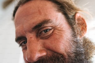 a close up of a man with a beard smiling