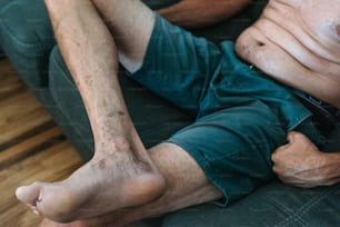 a man laying on a couch with his bare legs