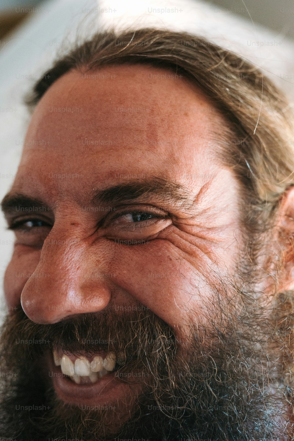 a close up of a man with a beard smiling