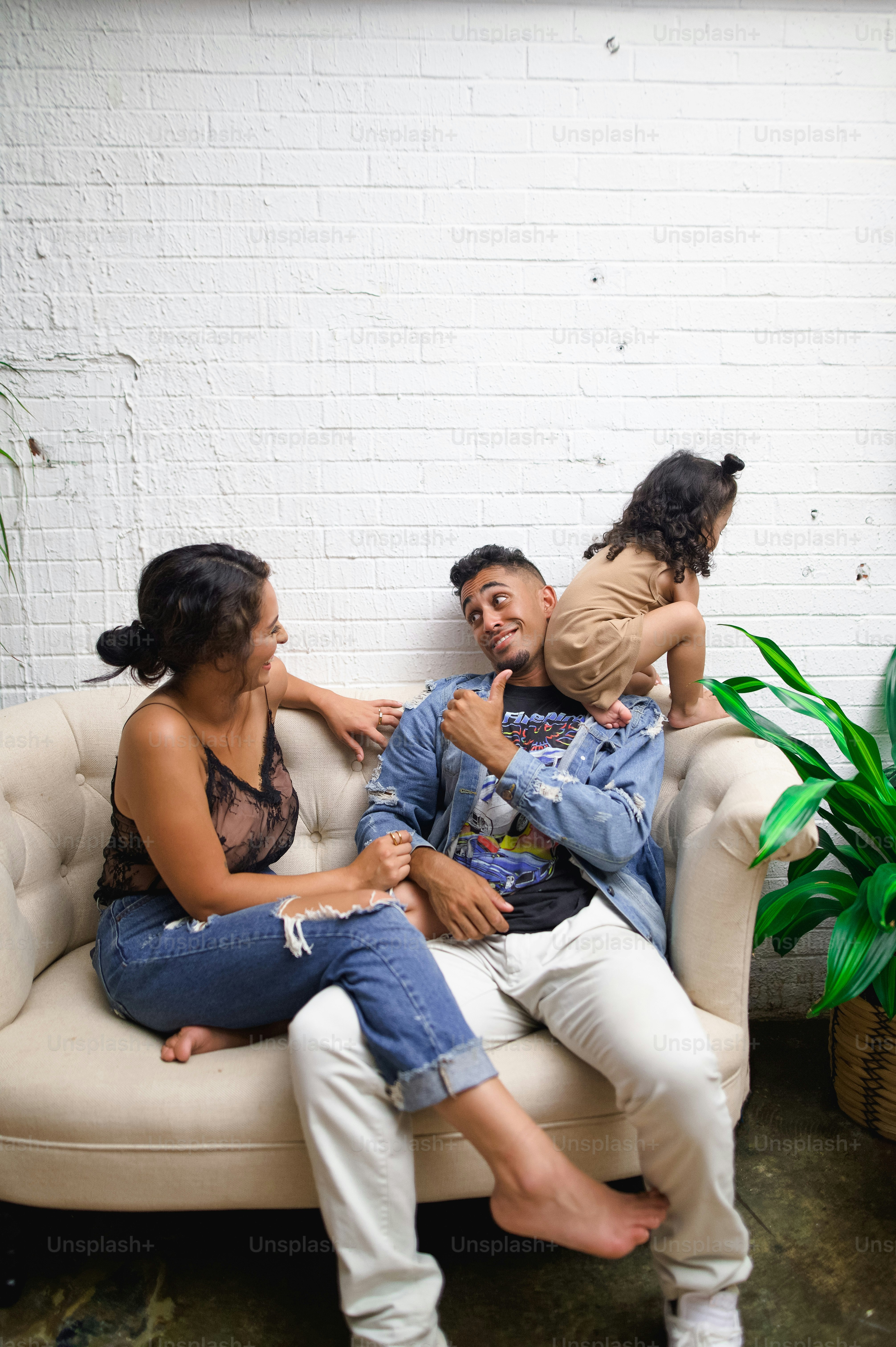 A group of people sitting on top of a couch photo – Family living room ...