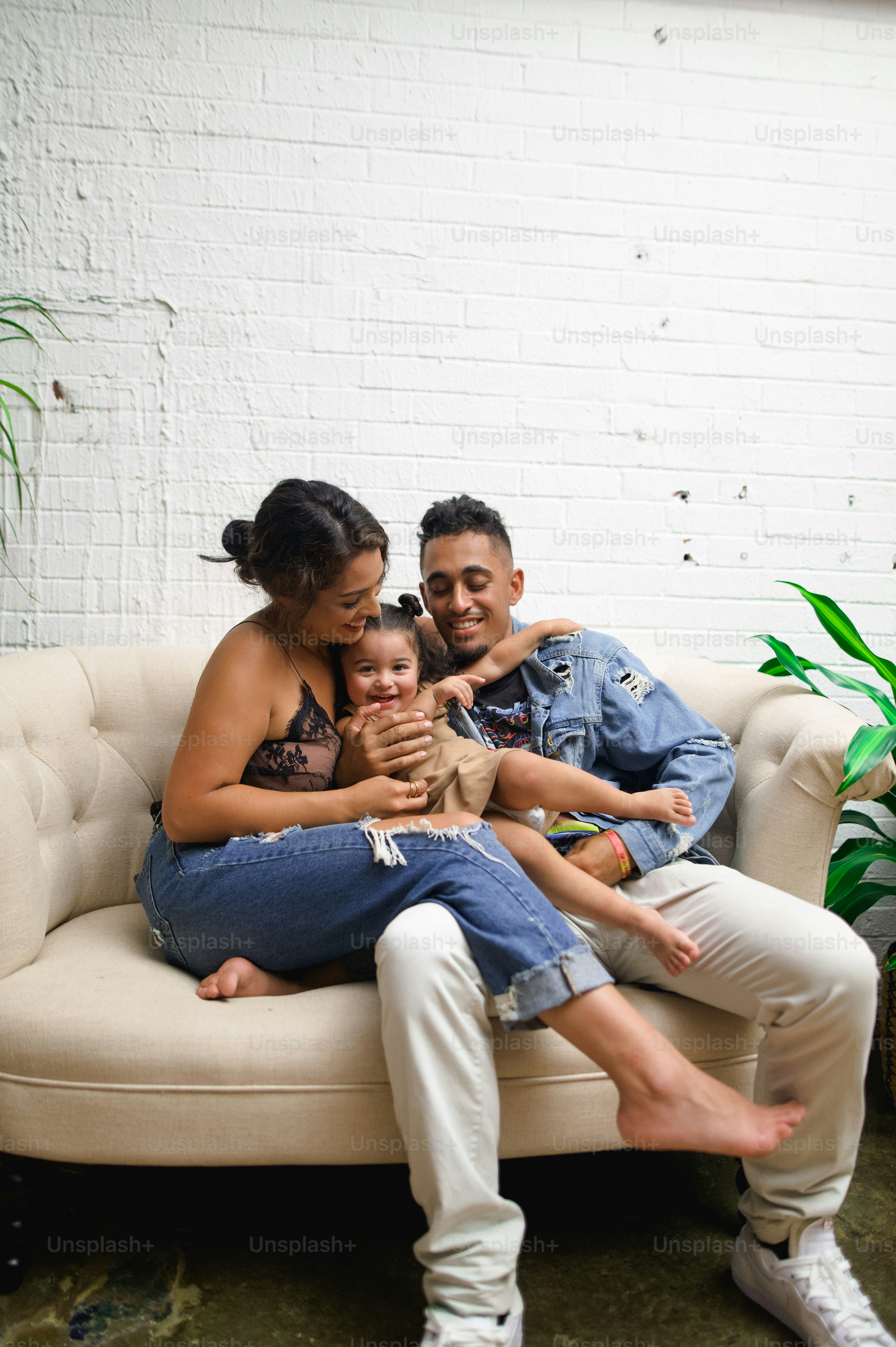 a man and woman sitting on a couch with a baby