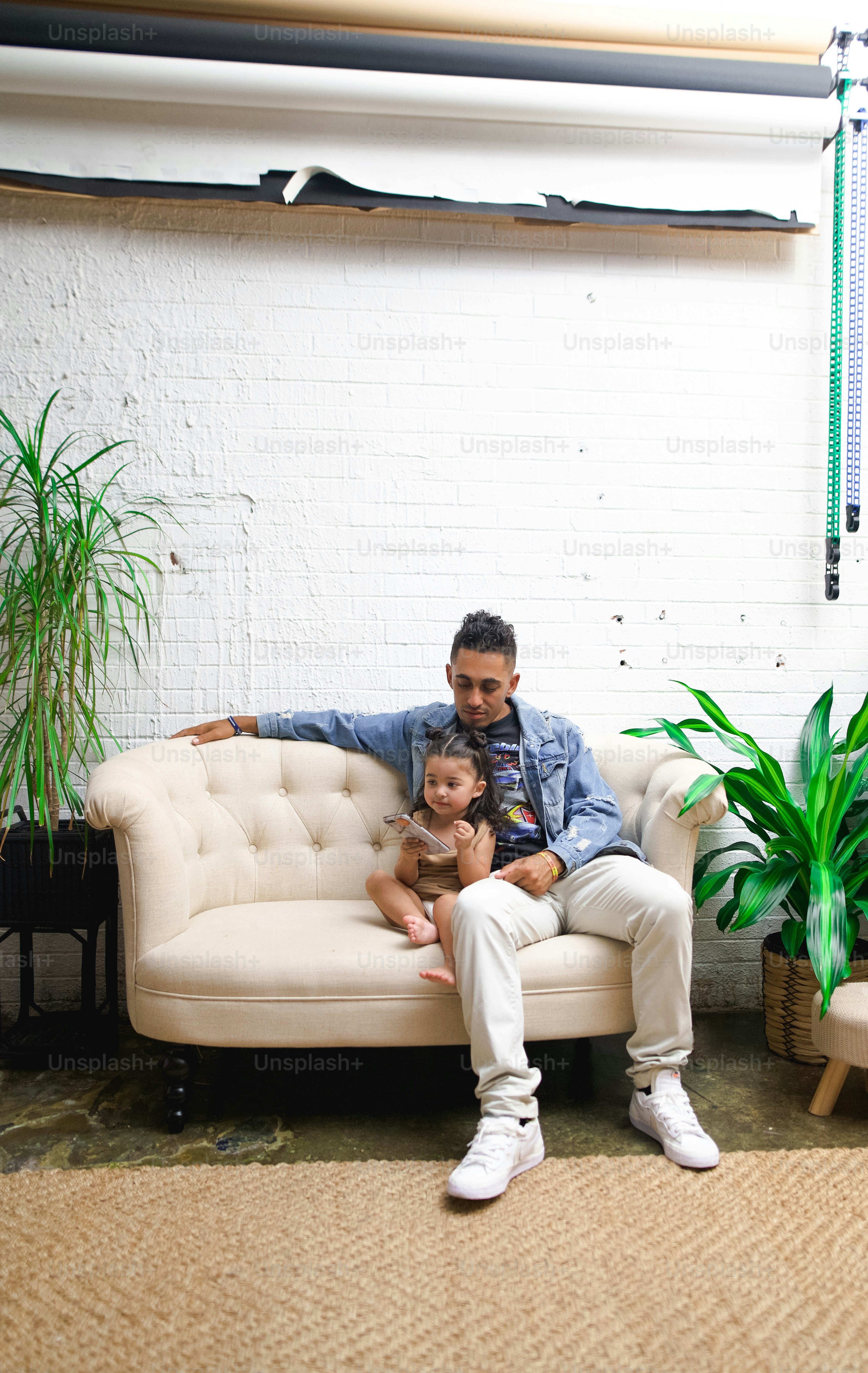 a man sitting on a couch with a little girl