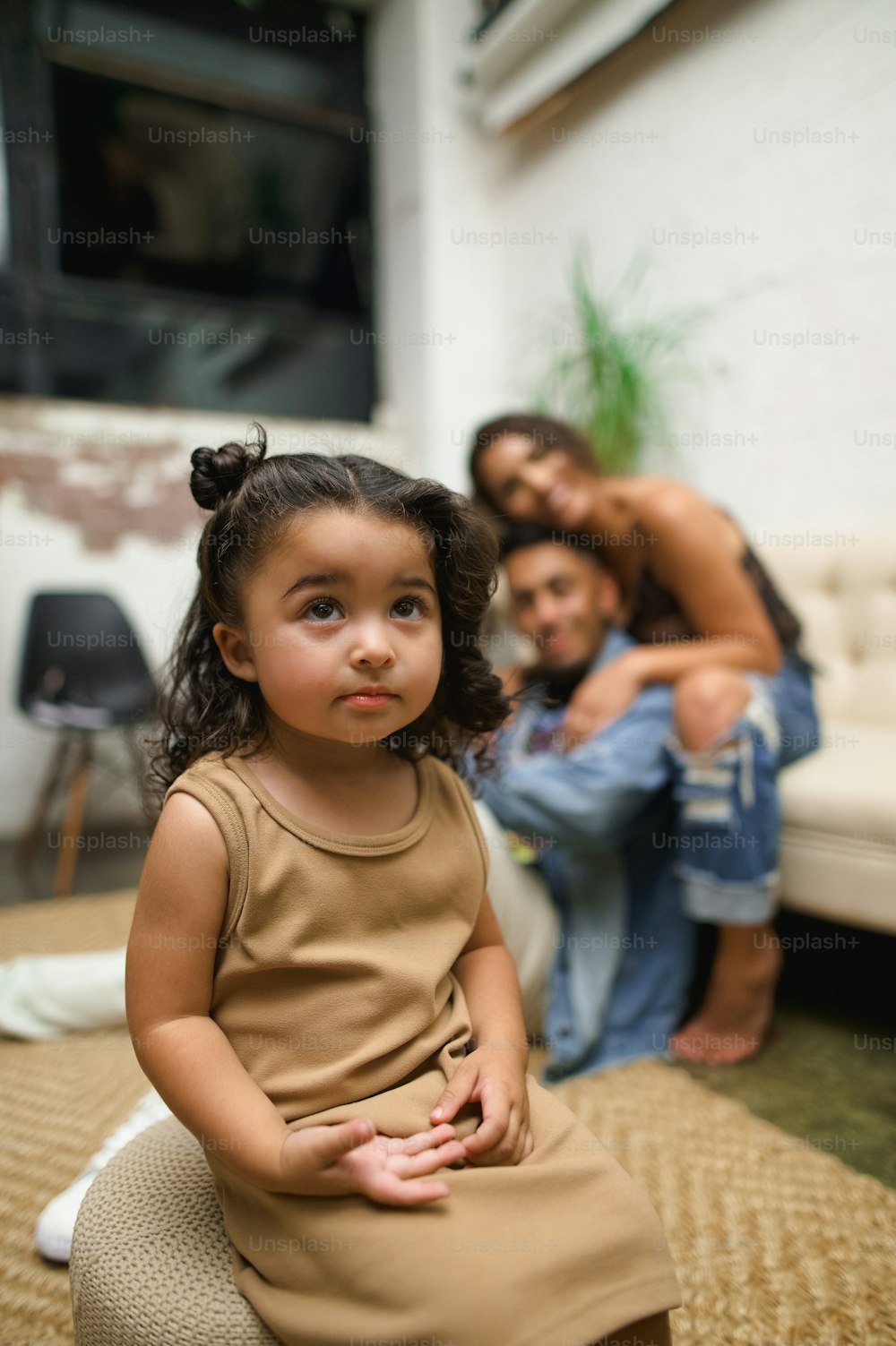 a little girl sitting on the floor next to a woman
