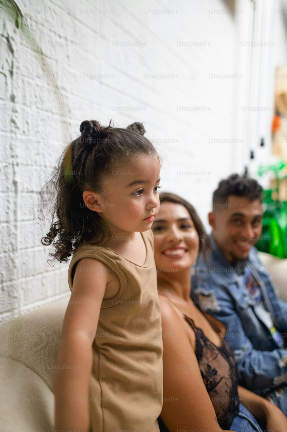 a man and a woman sitting on a couch with a little girl