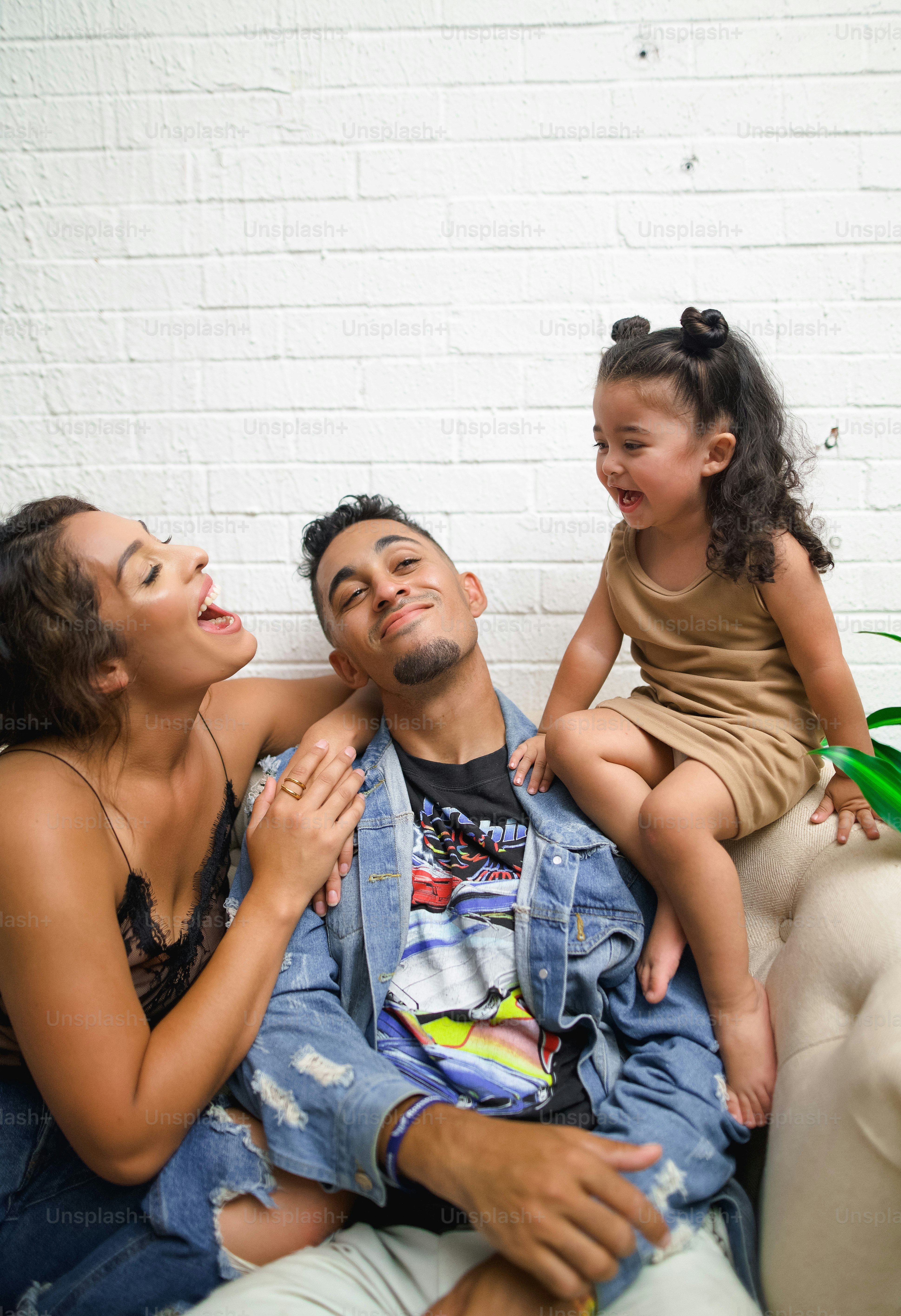 a man and a woman sitting on a couch with a little girl