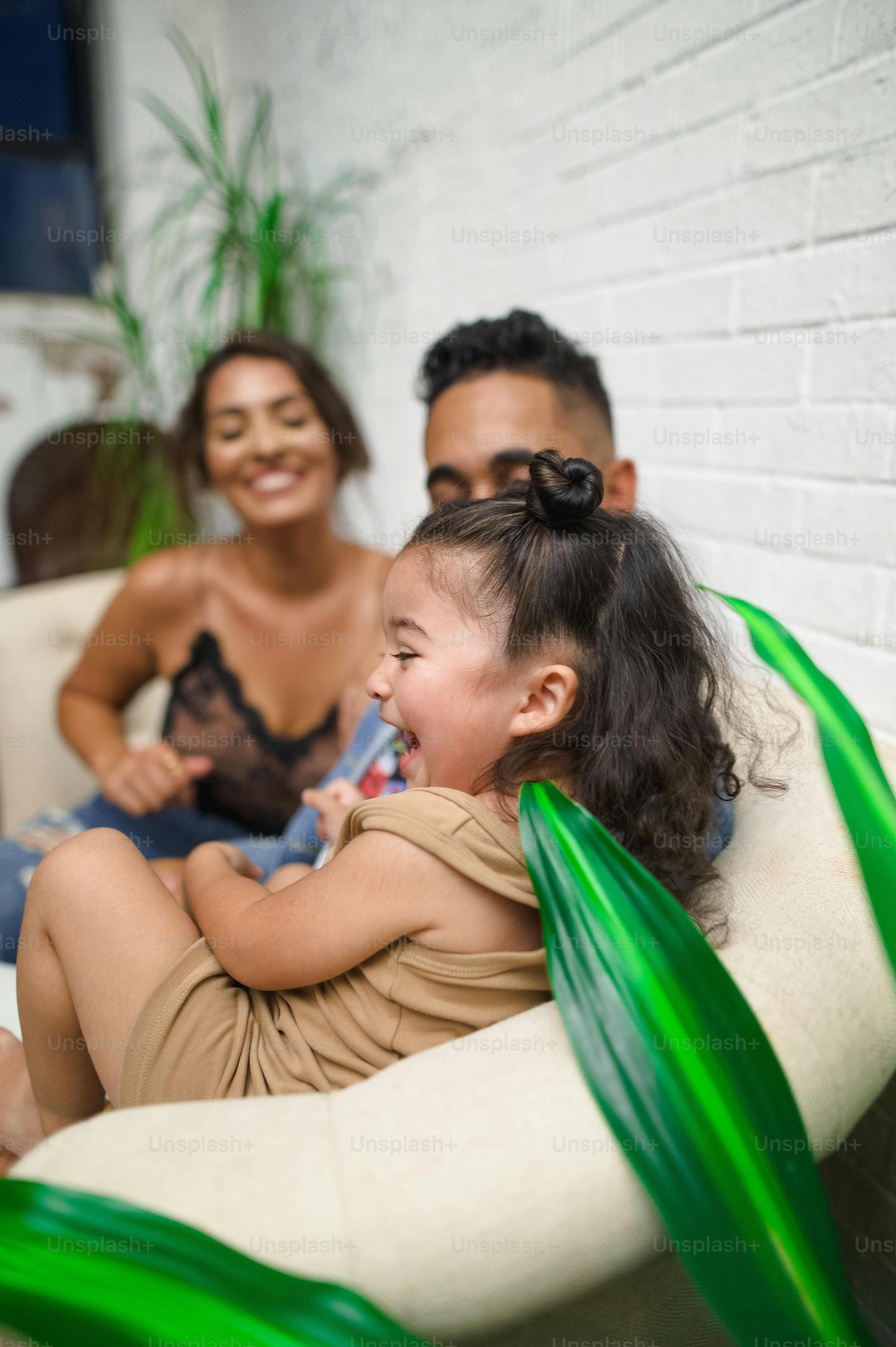 a woman and a man sitting on a couch with a little girl