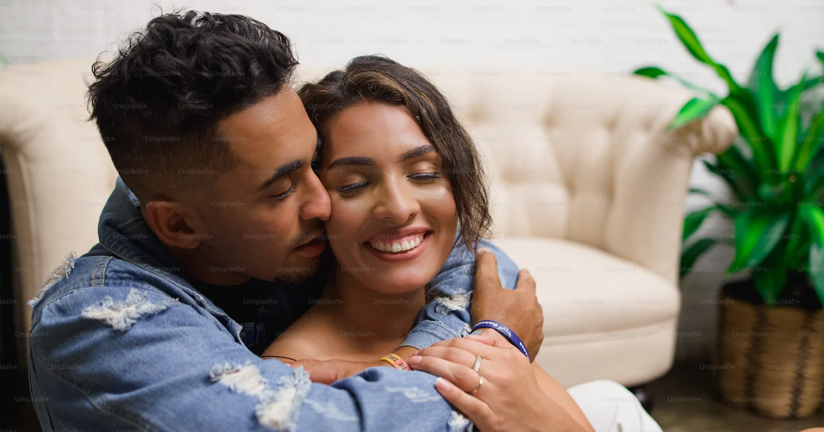 A man and woman sitting on a couch hugging photo – Man Image on Unsplash