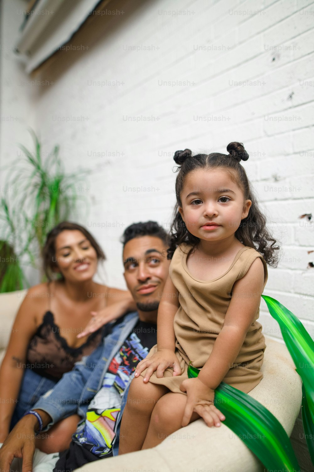 a little girl sitting on top of a couch next to a man