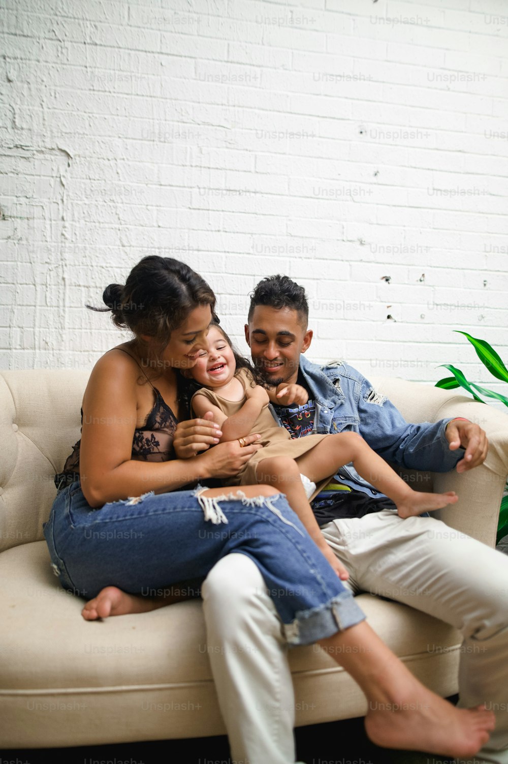 a man and woman sitting on a couch with a baby