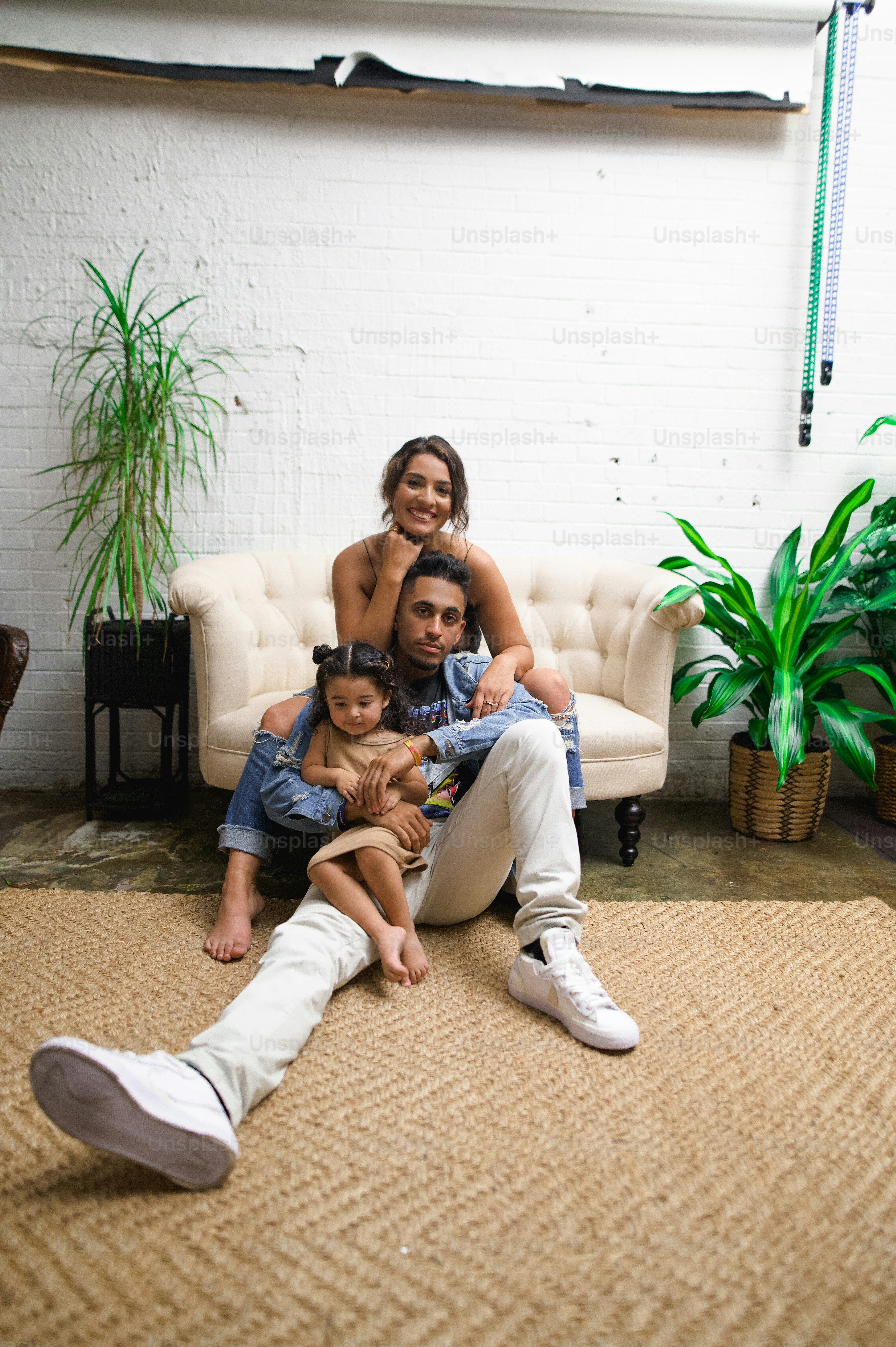 a man and woman sitting on a couch with a child