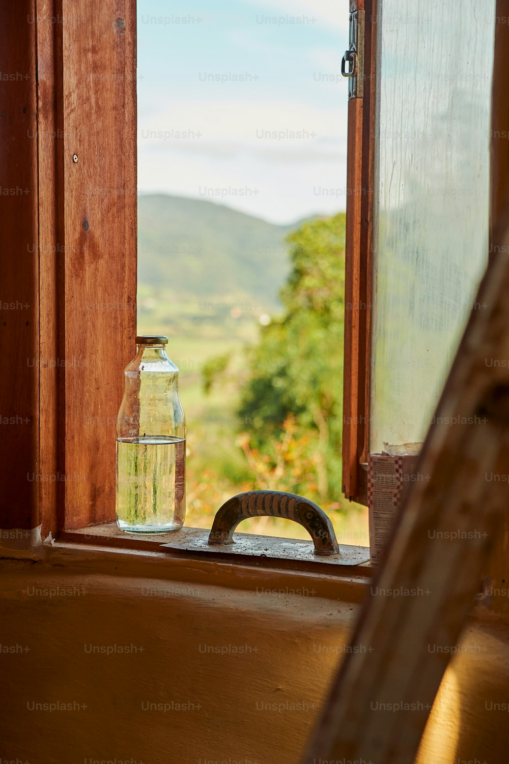 uma garrafa de água sentada no parapeito de uma janela