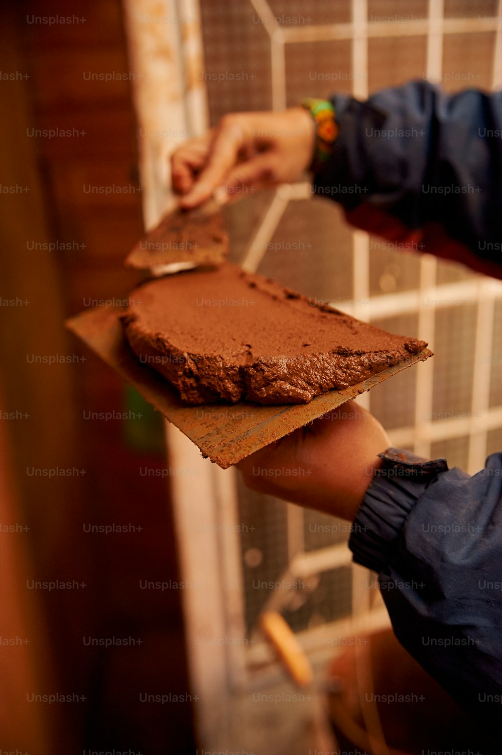 a person holding a piece of chocolate cake