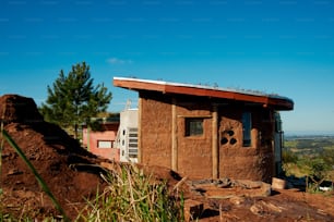 a small building sitting on top of a dirt hill