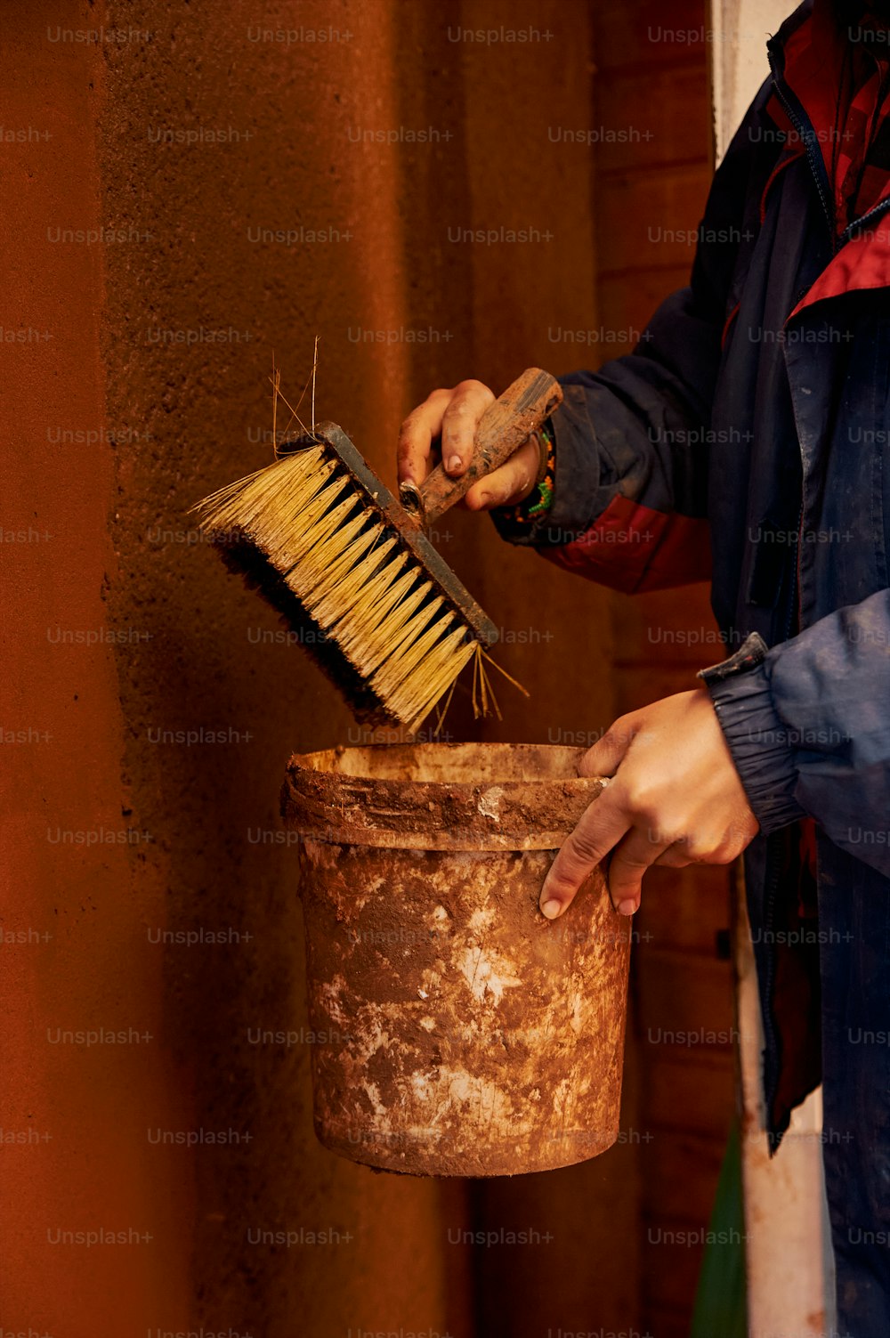 a person is holding a brush and a bucket