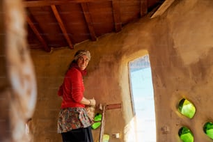 a woman in a red shirt is holding a skateboard