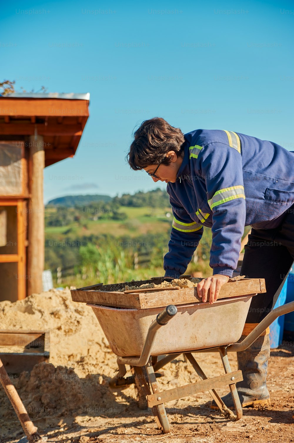 a man with a wheelbarrow digging in the dirt