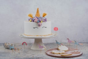 a white cake with a unicorn face on top of it