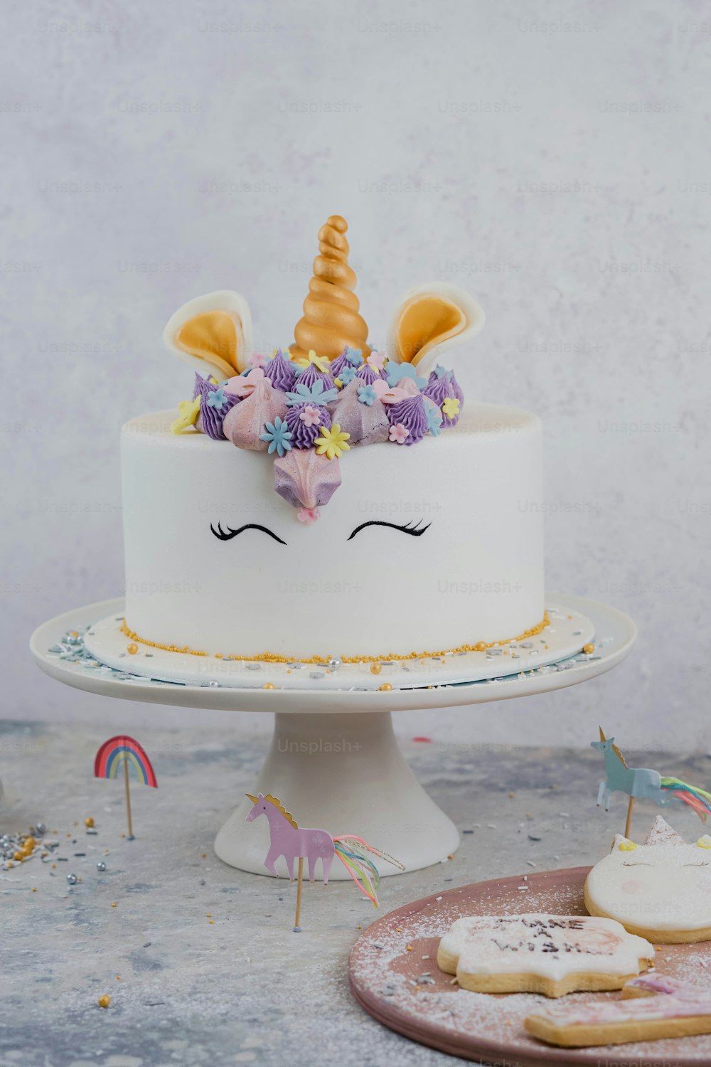Un pastel blanco con una cara de unicornio encima.