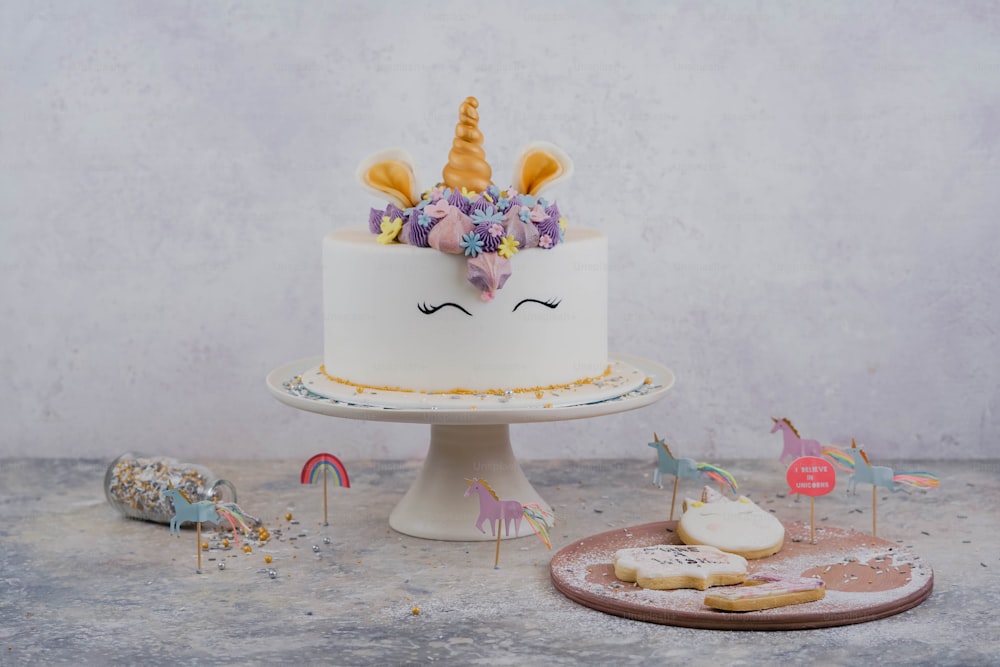a white cake with a unicorn face on top of it