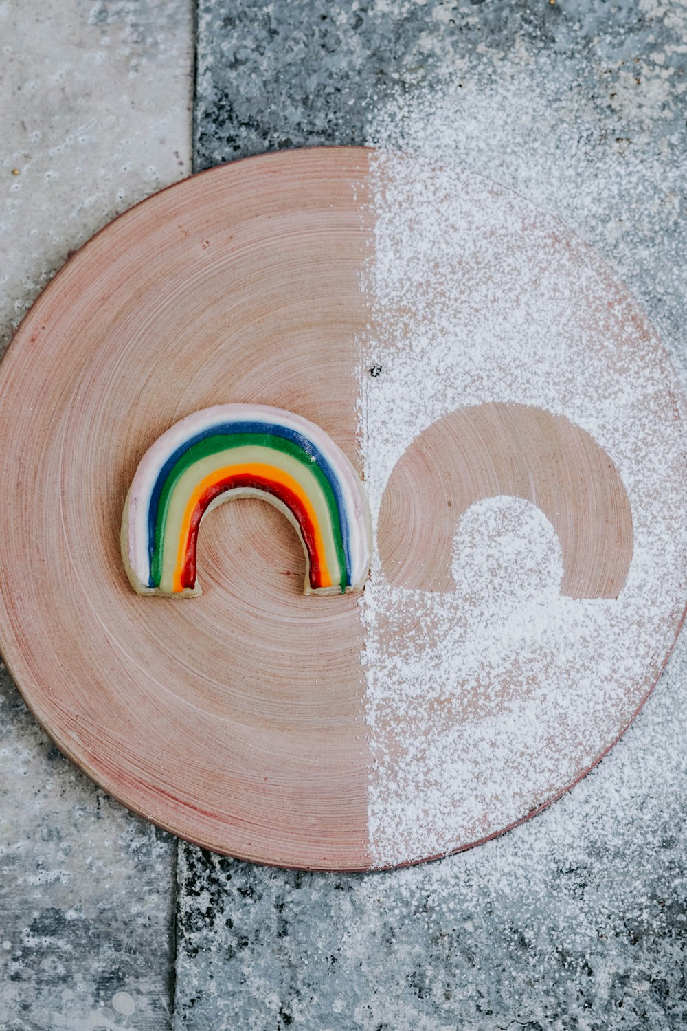 a wooden plate topped with a rainbow cookie