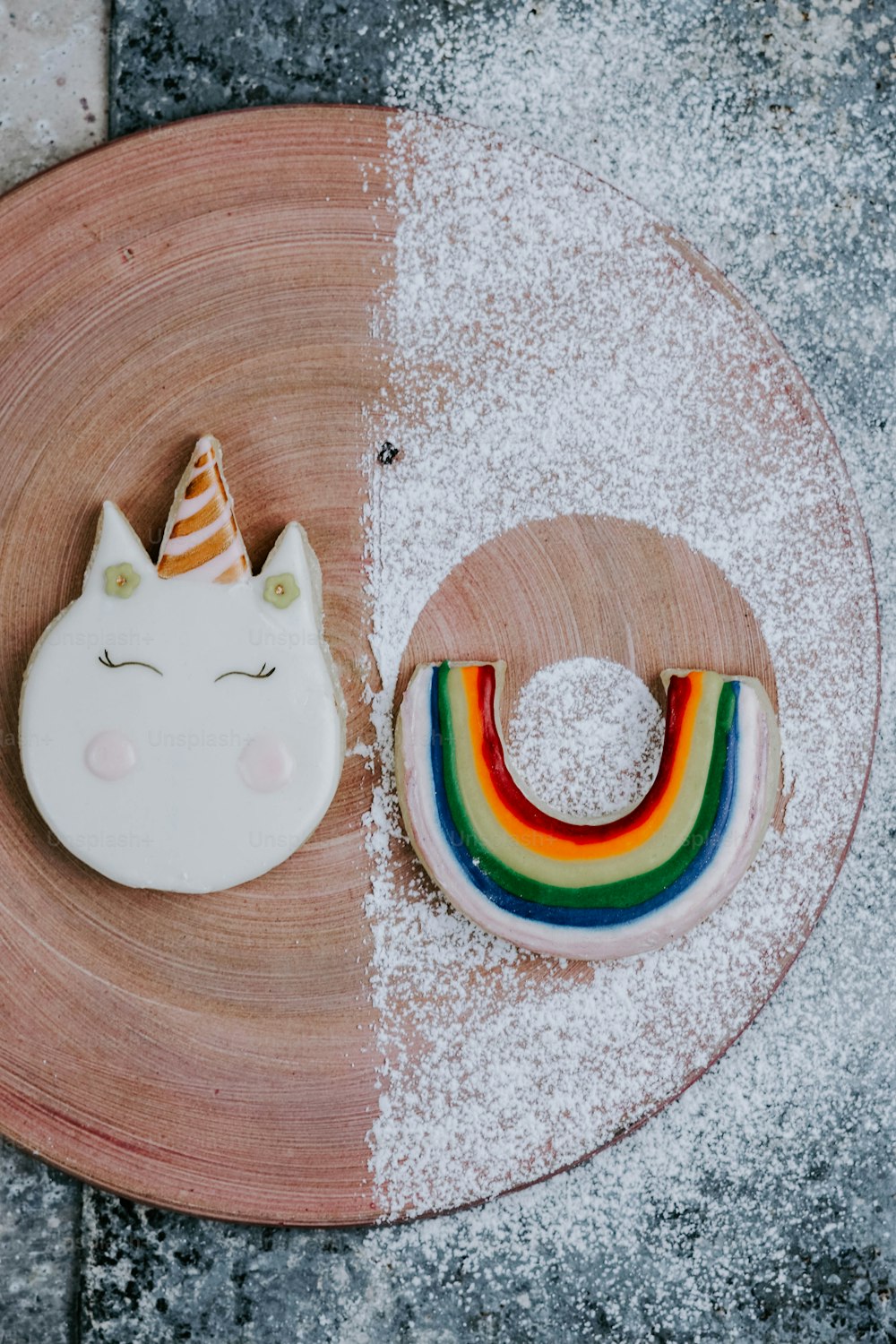 um prato com um biscoito unicórnio e um biscoito arco-íris