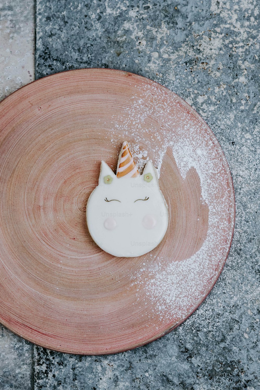 a plate with a cake shaped like a unicorn