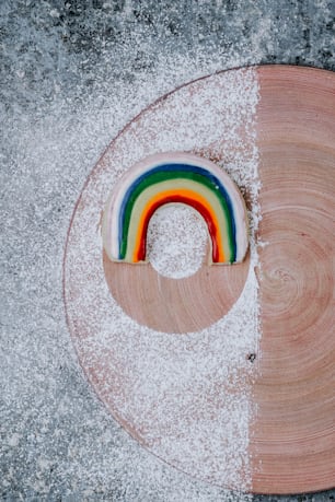 a wooden plate with a rainbow decoration on it