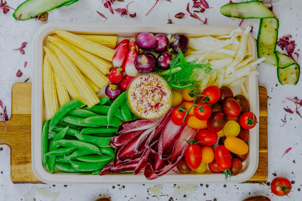 une variété de légumes sont disposés sur une planche à découper