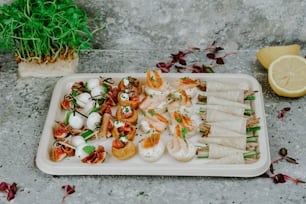 a tray of food on a table next to a potted plant