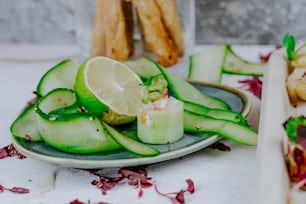a plate of food with cucumbers and lemon slices