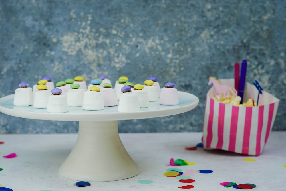 a table topped with a cake covered in white frosting