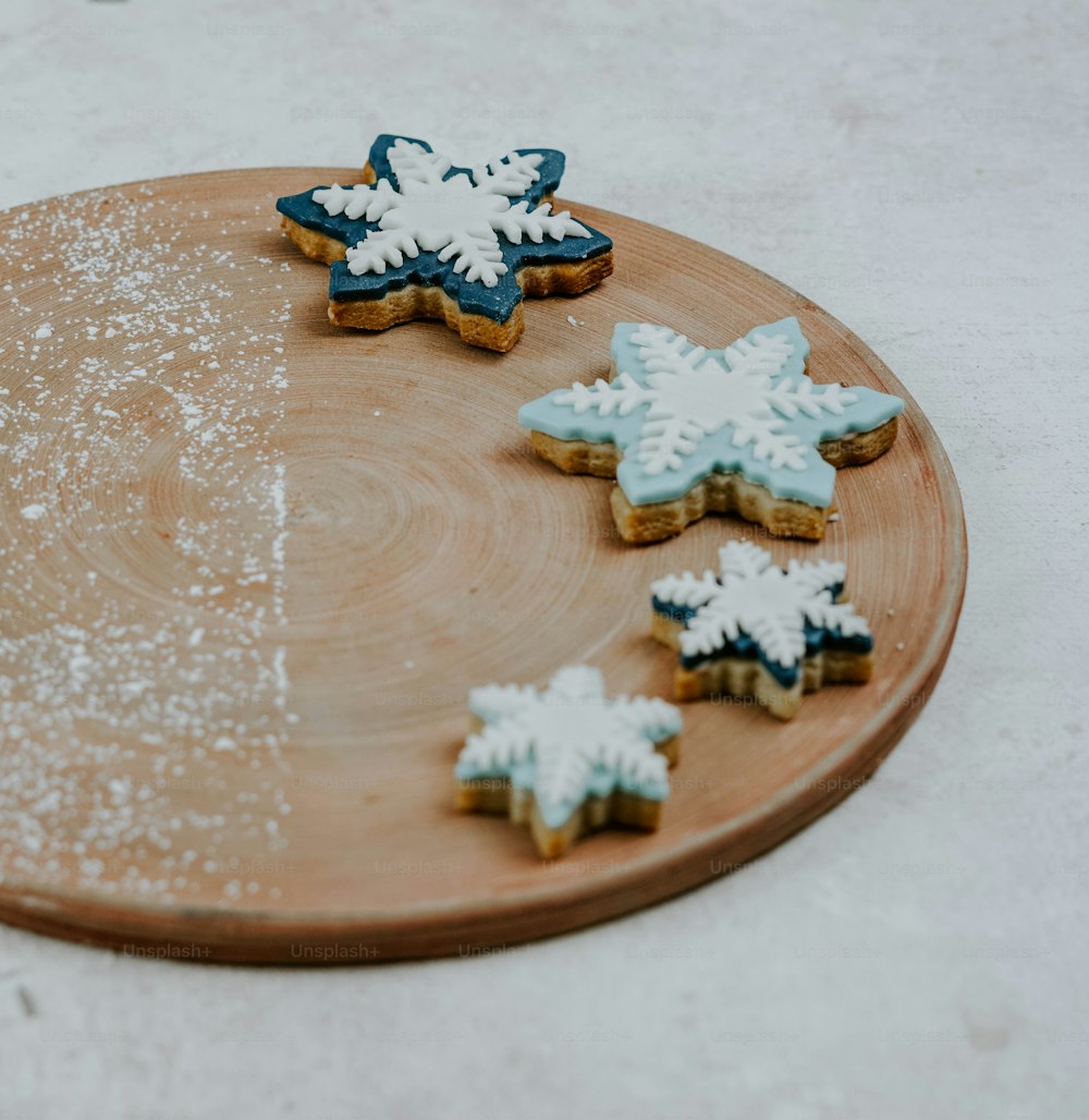 um prato de madeira coberto com biscoitos cobertos de glacê