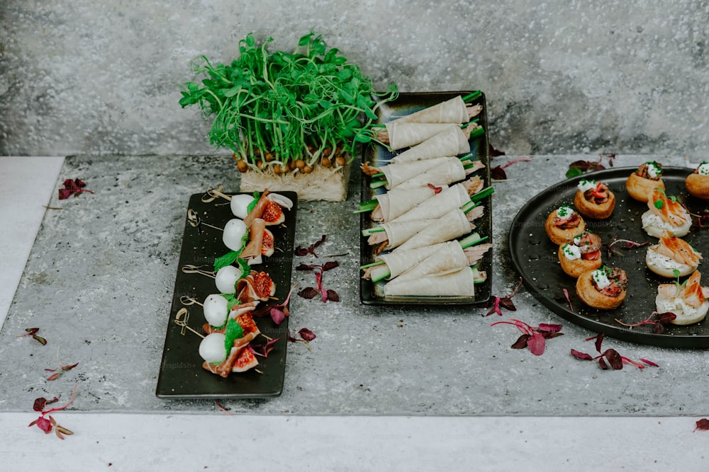 uma mesa coberta com pratos de comida ao lado de uma planta