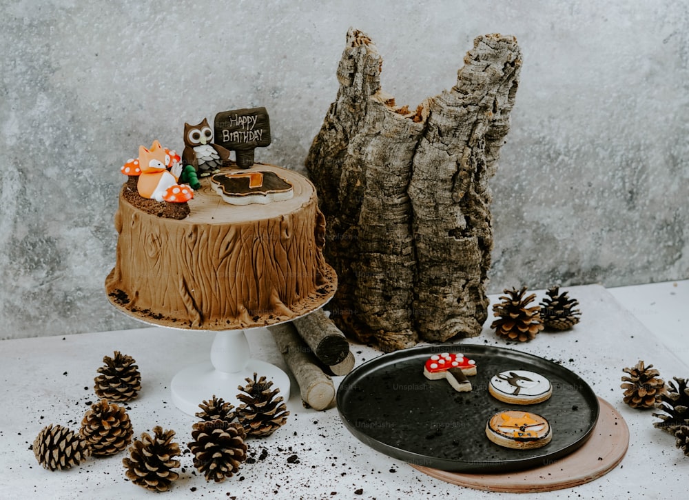 a cake on a plate next to some pine cones