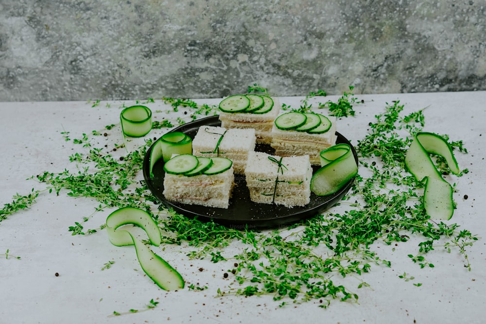 a plate of cucumber sandwiches on a table