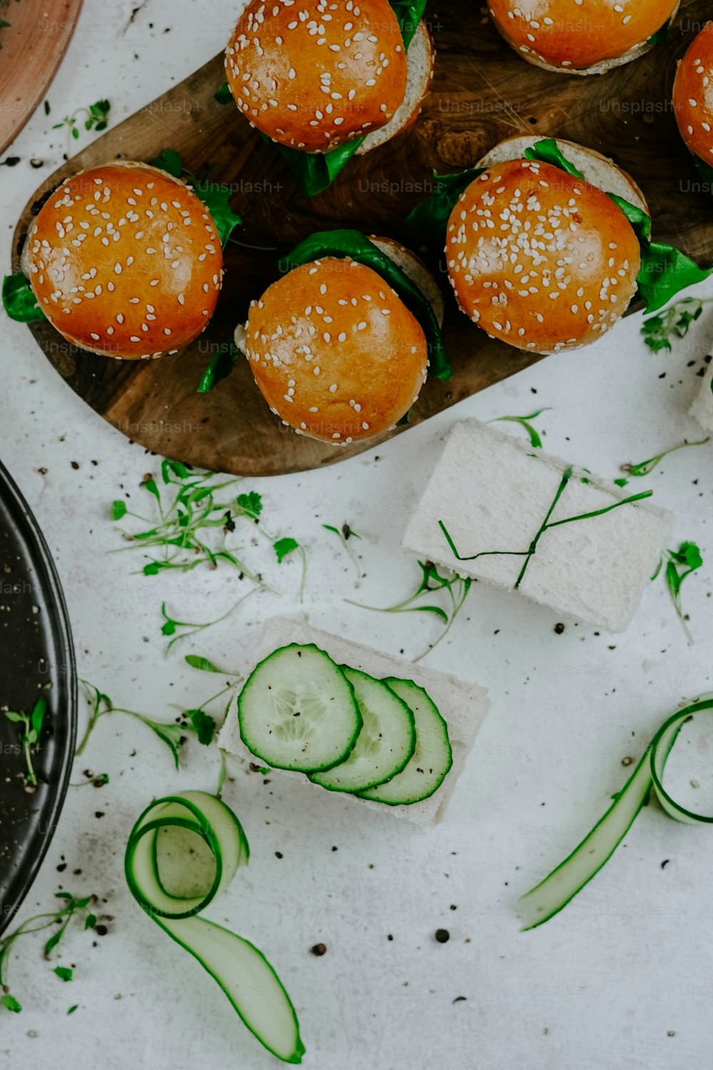 a table topped with cucumbers and mini sandwiches