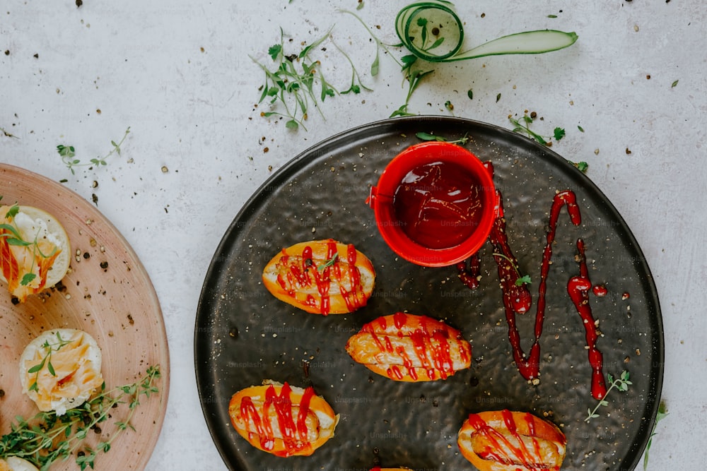 a plate of deviled eggs with ketchup next to a plate of devil