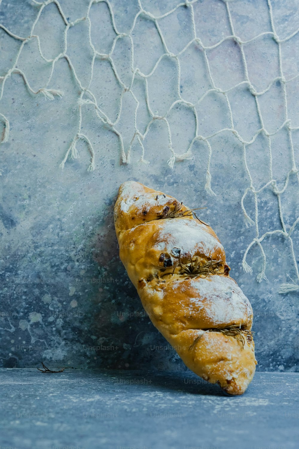 Un pedazo de pan sentado encima de una superficie azul