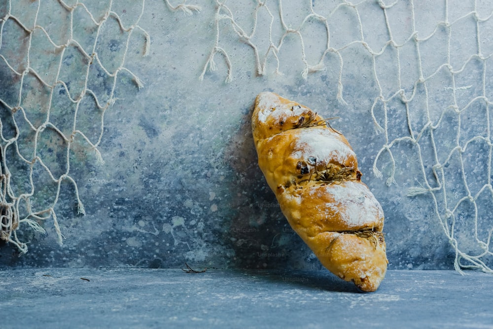 Un pedazo de pan sentado encima de una superficie azul