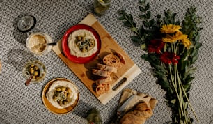 a table topped with bowls of food next to flowers