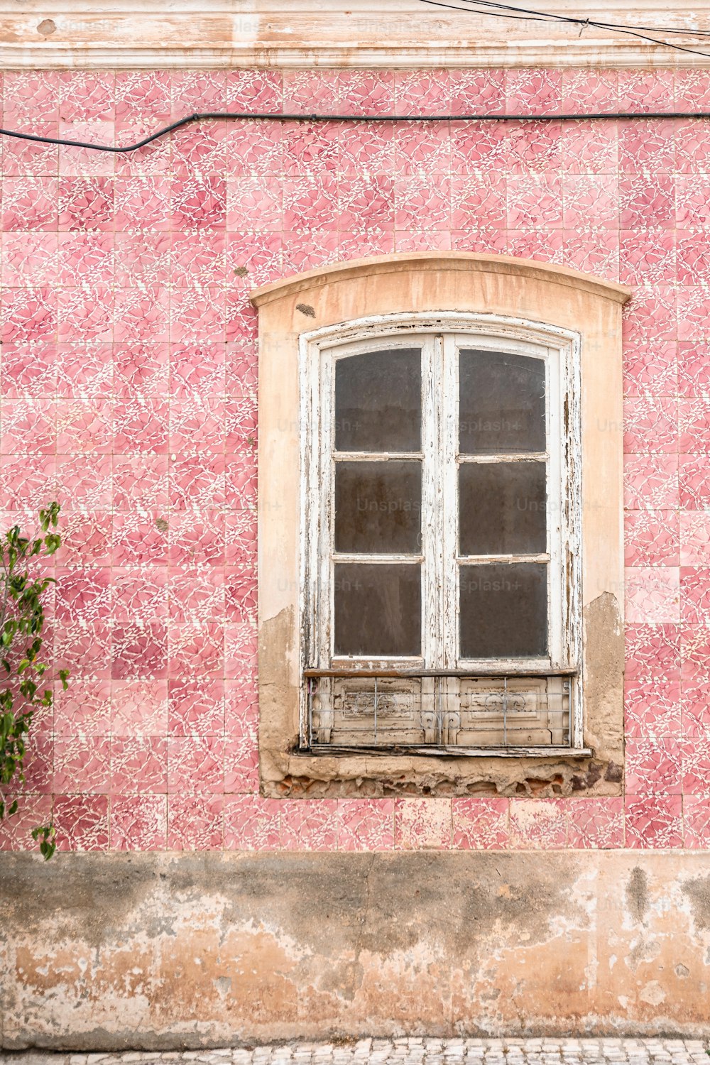 a window on the side of a pink building