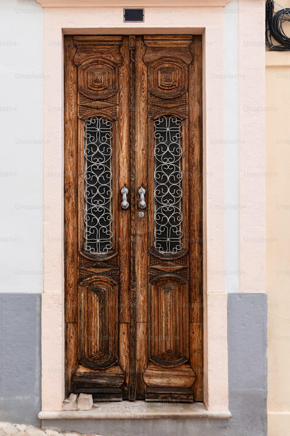 a pair of wooden doors on the side of a building