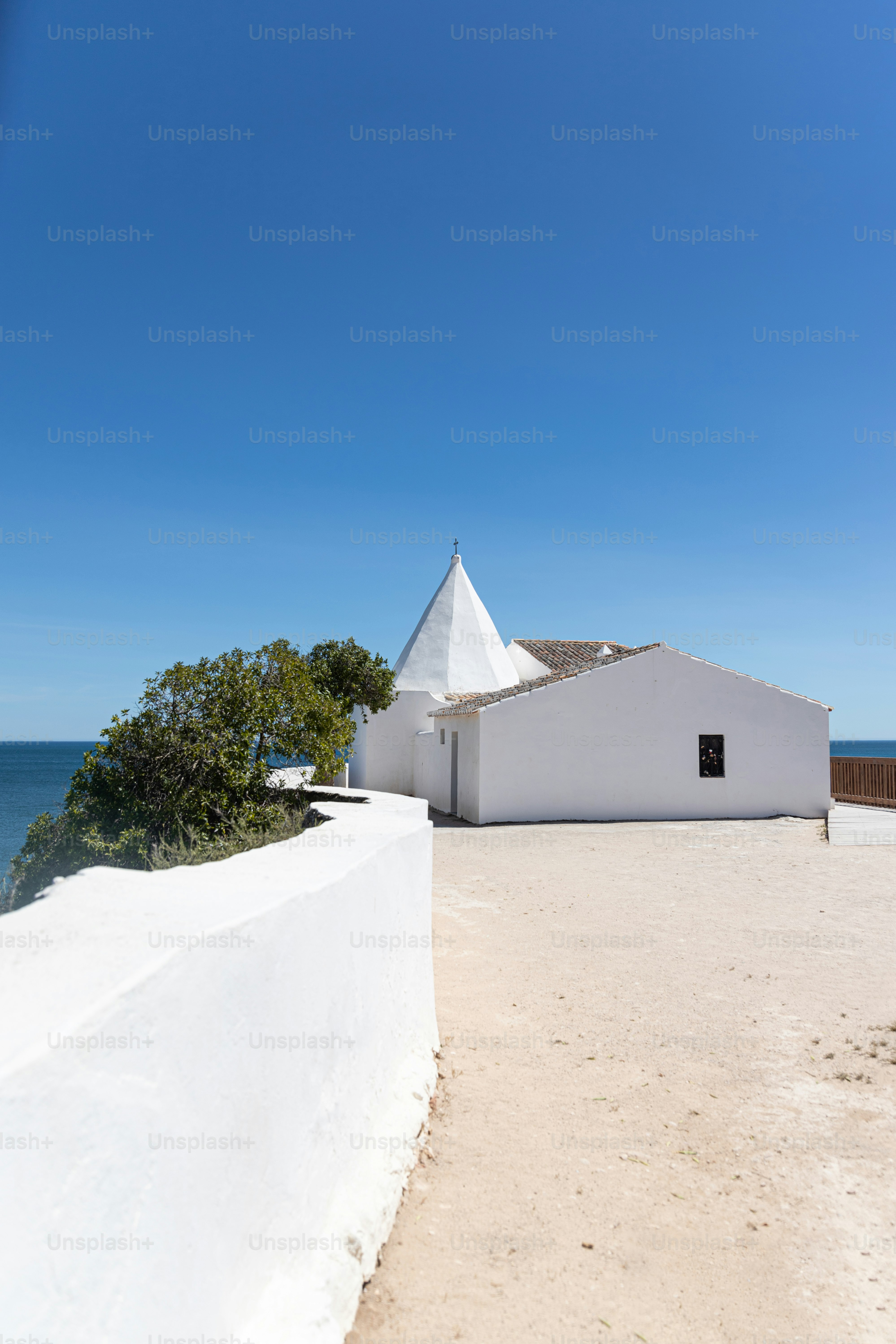 a white building sitting on top of a sandy beach