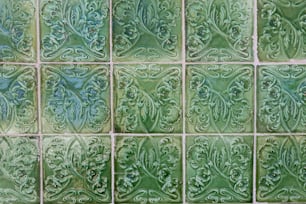 Un primo piano di un muro di piastrelle verdi