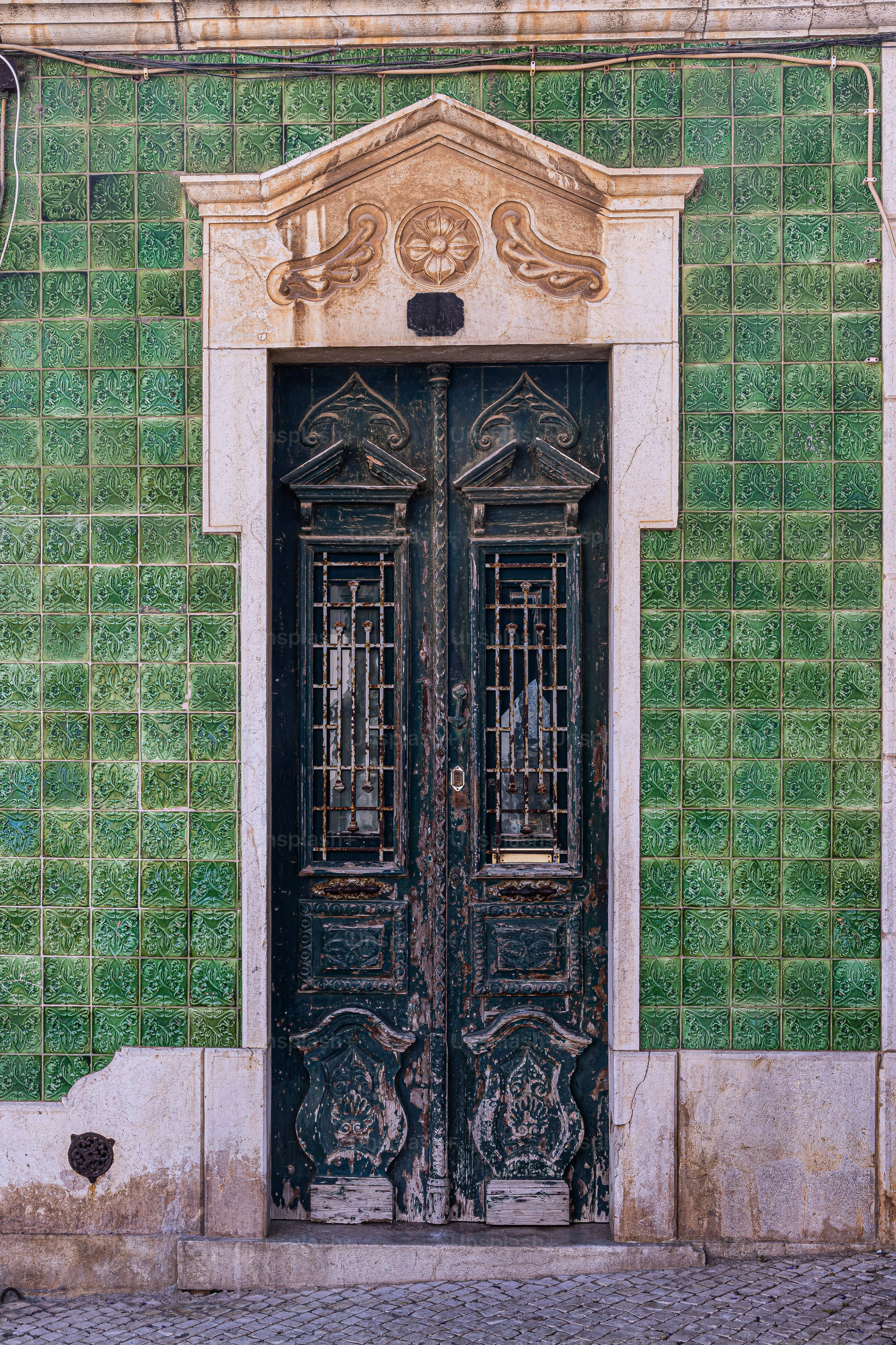 a green and white building with a black door