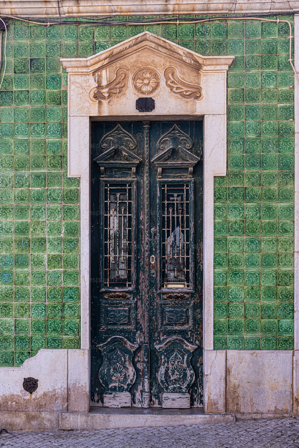 a green and white building with a black door