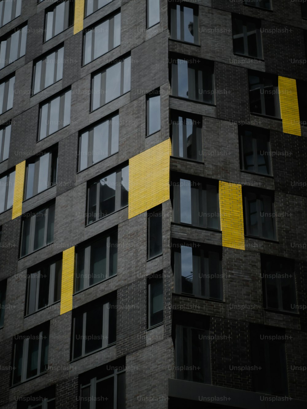 a tall building with windows and yellow tape on it