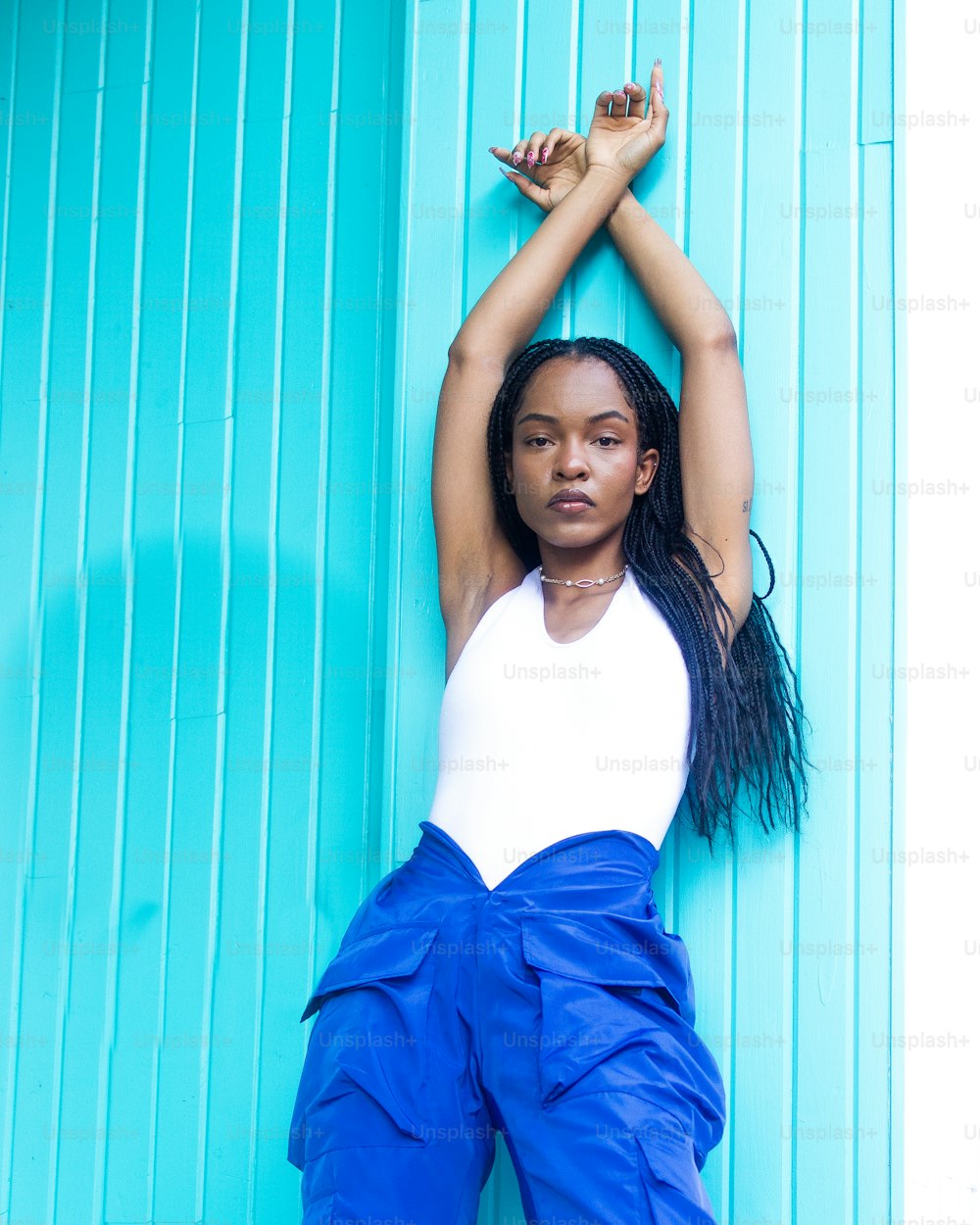 a woman leaning up against a blue wall